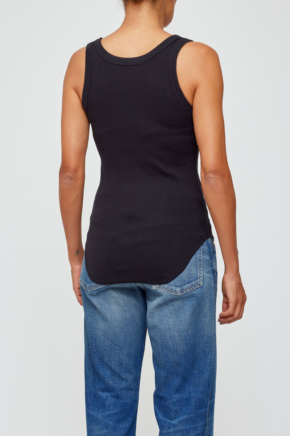 Black sleeveless tank top worn with blue jeans shown from back view