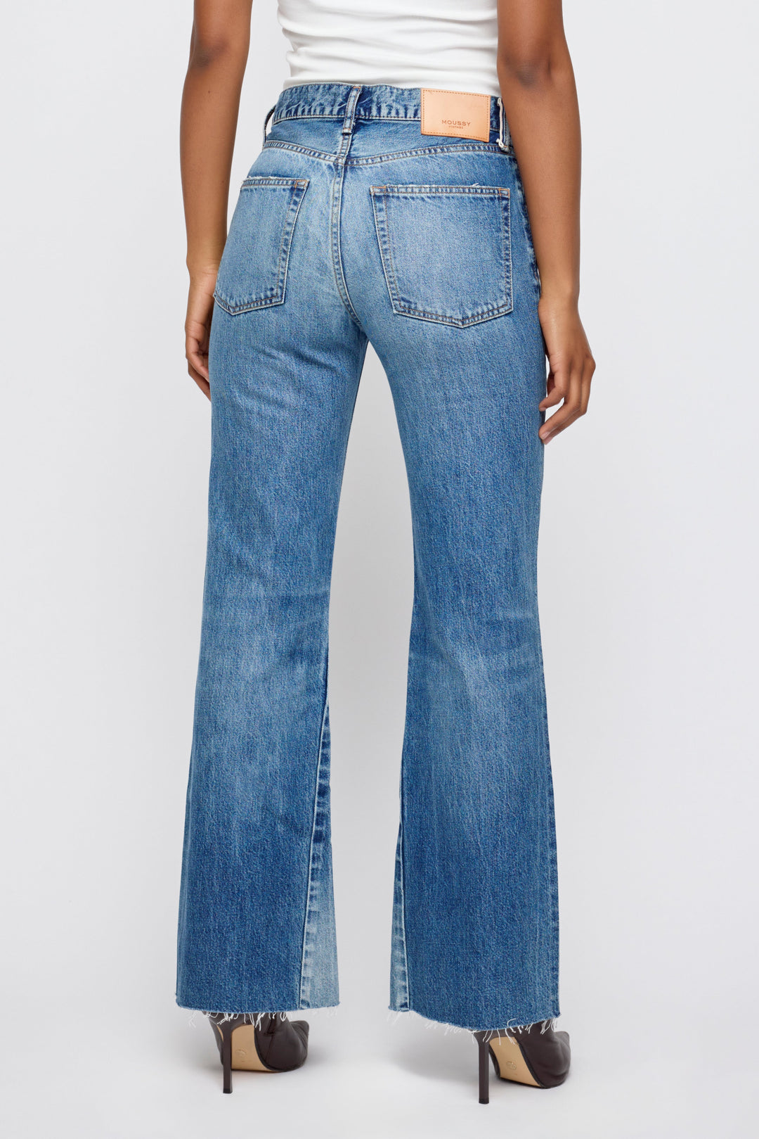 Back view of Moussy Vintage Remake Flare jeans in medium blue wash with frayed hem