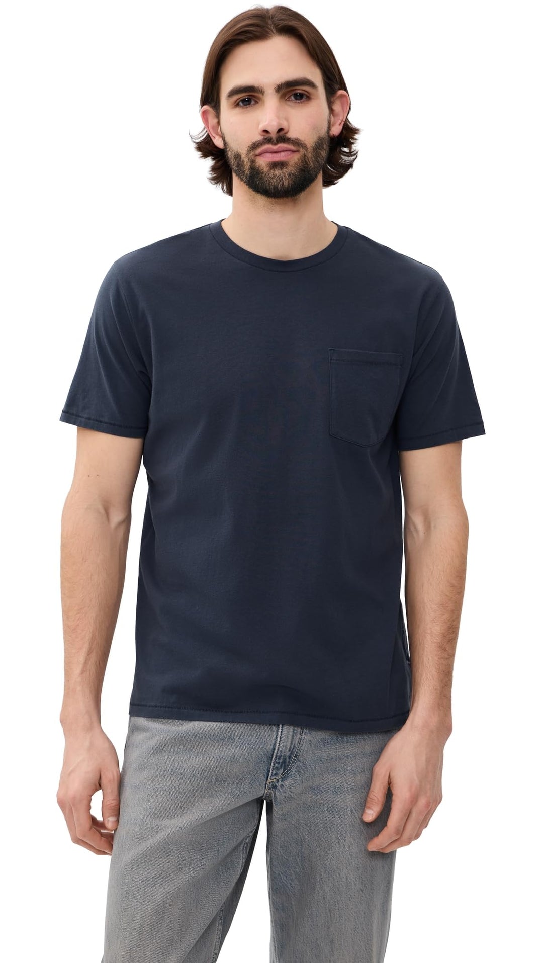 Man wearing navy blue Rag & Bone garment dye classic pocket tee with gray jeans