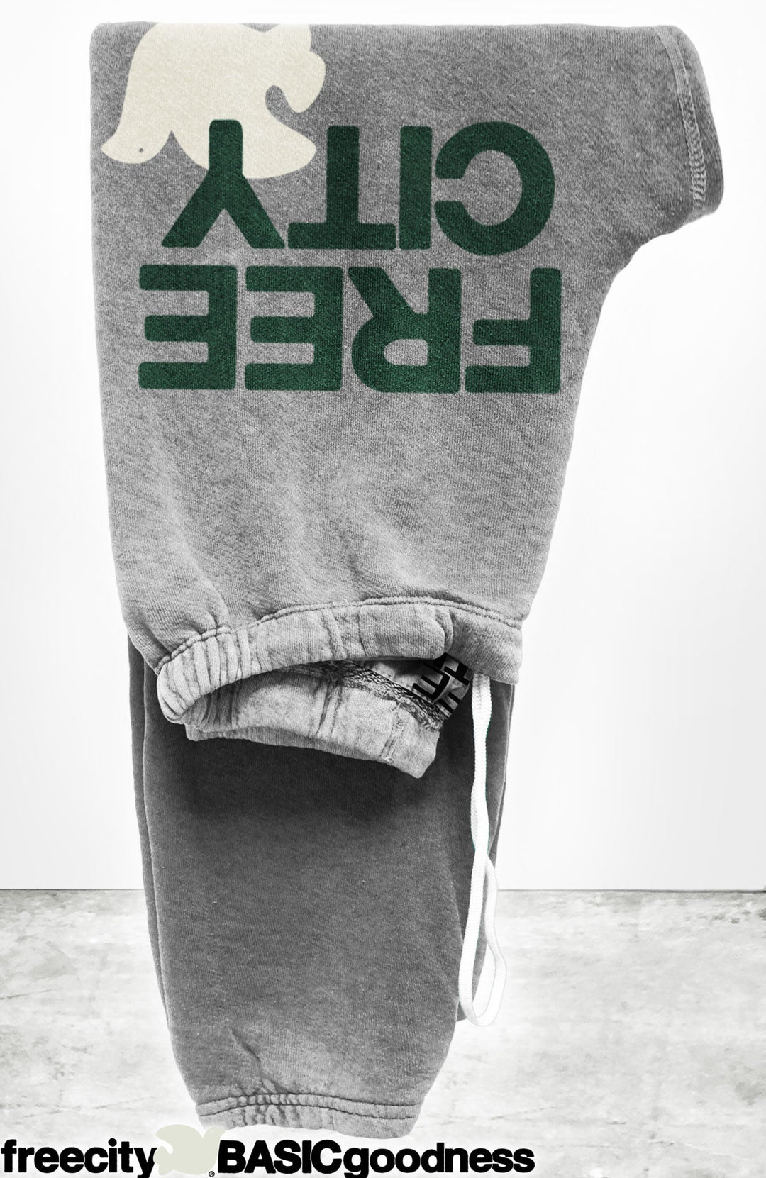 Free City grey sweatpants with green text and white logo detail