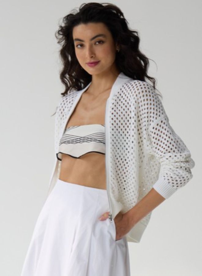 White mesh knit bomber jacket worn open over crop top and white pants