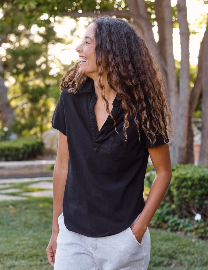 Woman wearing black Frank & Eileen Charlotte Perfect Polo shirt in outdoor setting