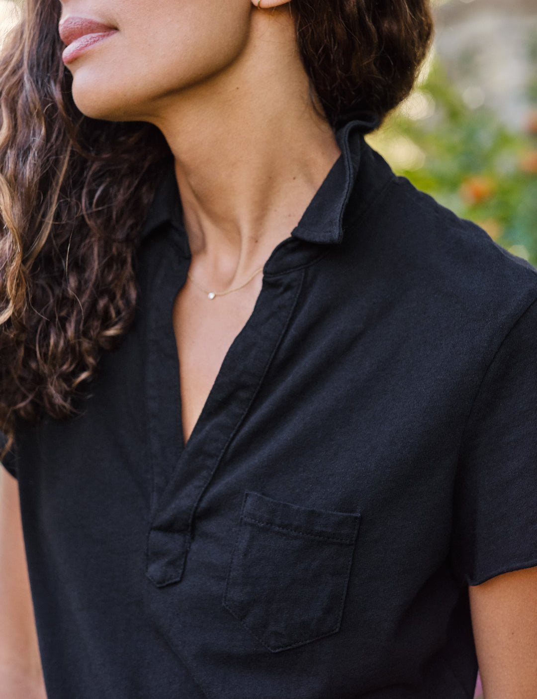 Woman wearing black Frank & Eileen Charlotte polo shirt with collar and chest pocket