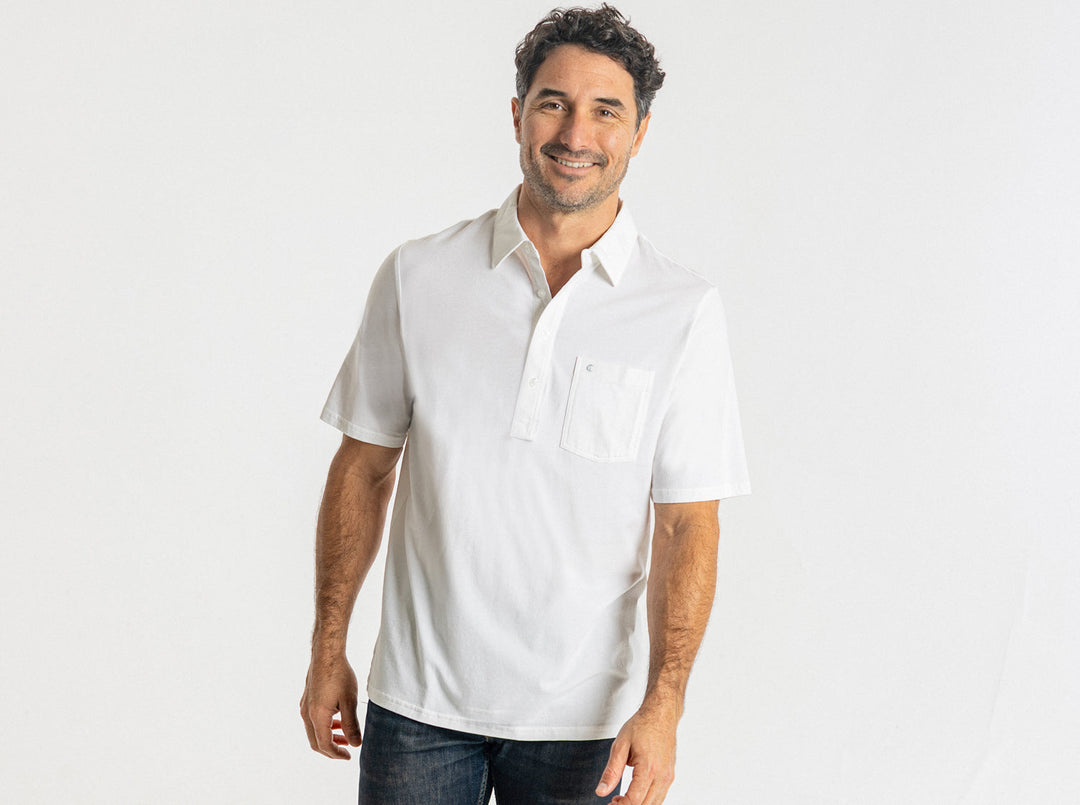 Man wearing white short-sleeve polo shirt with chest pocket and jeans