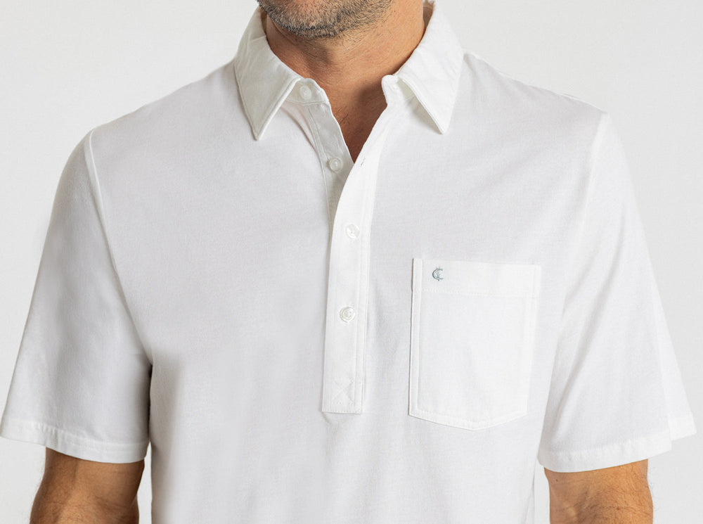 White short sleeve polo shirt with collar and chest pocket on model