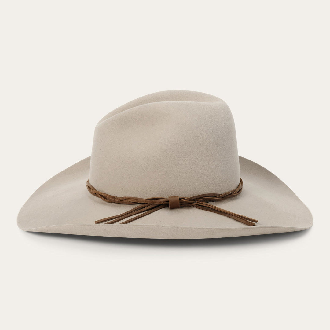 Beige wide-brimmed cowboy hat with brown leather braided hatband and tassels