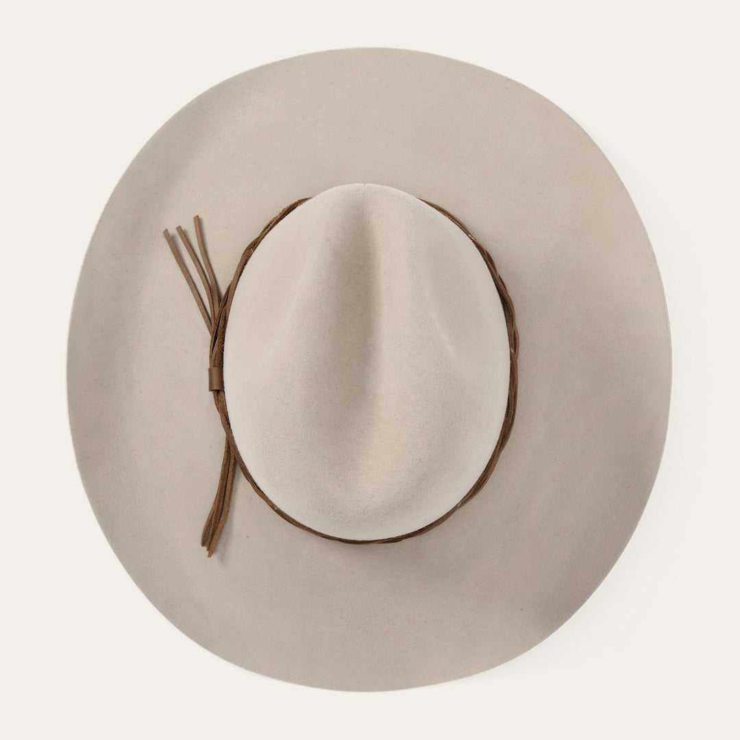 Beige wide-brimmed hat with brown leather band and decorative ties
