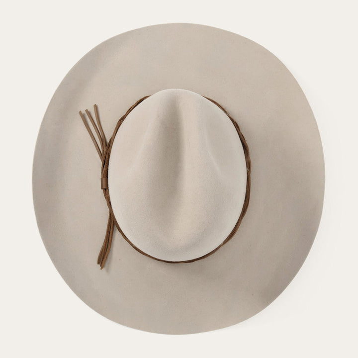 Beige wide-brimmed hat with brown leather band and decorative ties