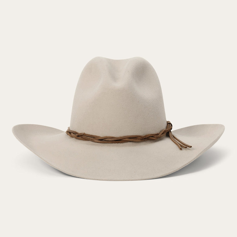 Light beige western hat with brown leather braided hatband on neutral background